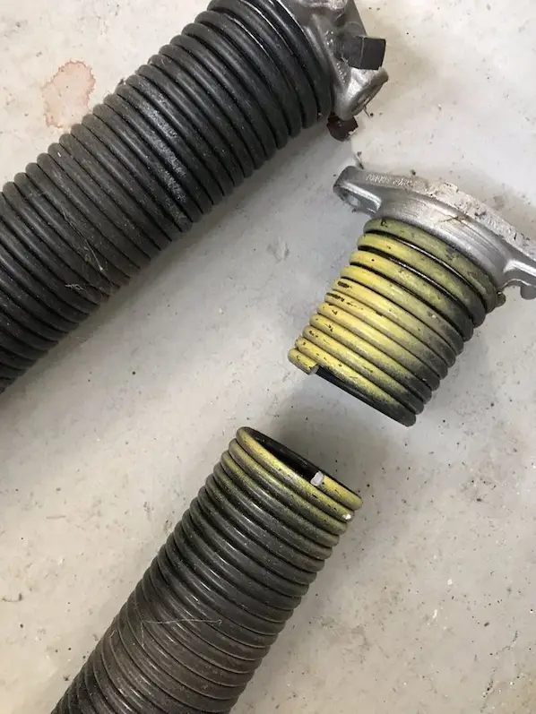 Close-up of a broken garage door spring with visible gap requiring repair in Durham NC